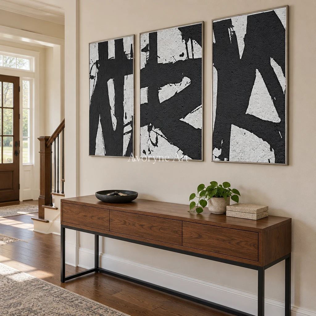 Muted Field black white brushwork triptych with a silver frame in an entryway