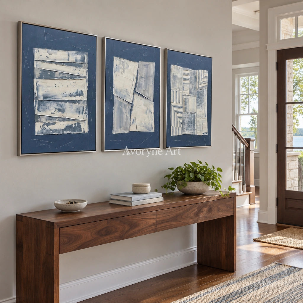 Hushed Solace blue geometric texture triptych with a silver frame in an entryway