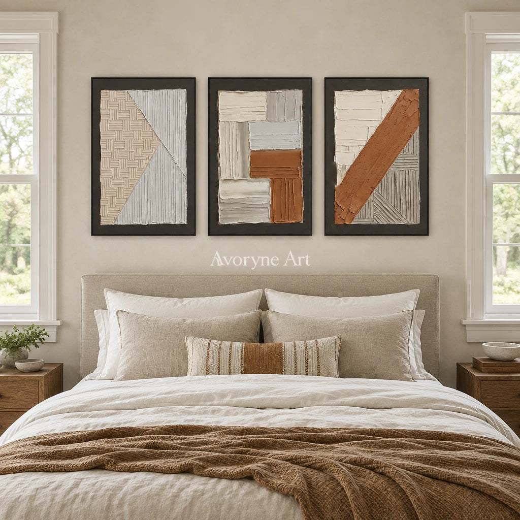 Soft Field neutral geometric relief triptych with a black frame above a bed in a bedroom