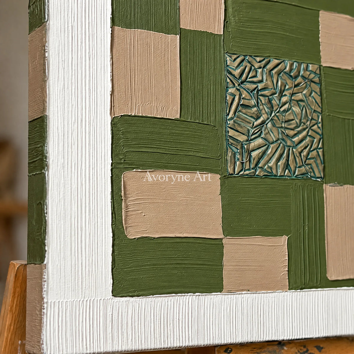 Close-up of the hand-painted texture of Hushed Horizon olive ivory grid wall art on an easel