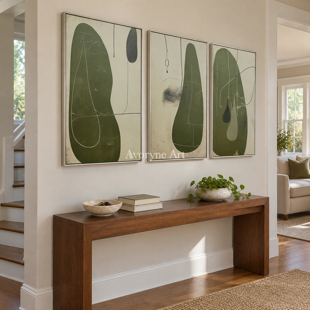 Muted Rhythm olive organic art triptych with a silver frame in an entryway