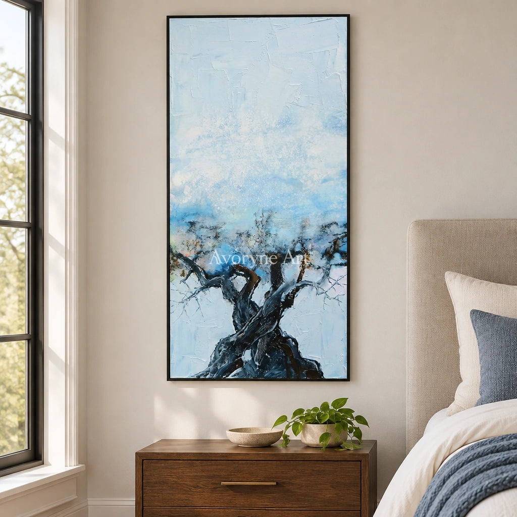 Blue Story snow branch wall art with a black frame above a bed in a bedroom