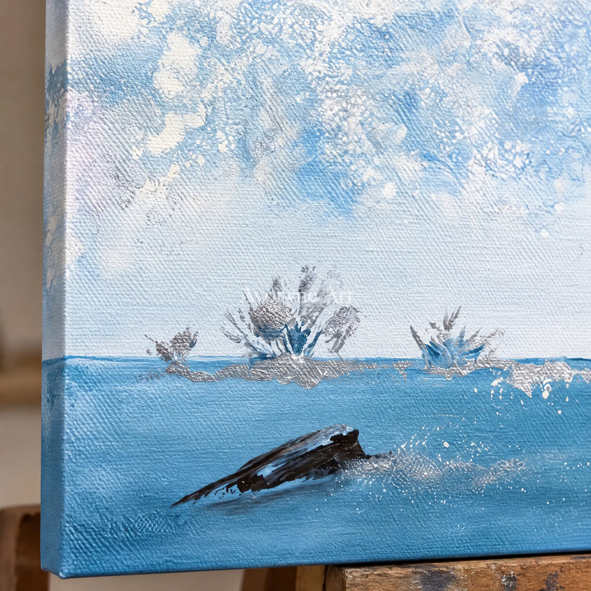 Close-up of the hand-painted texture of Blue Current snow branch wall art on an easel