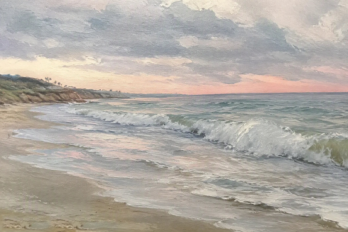 Soft coastal waves under a pale pink and grey sky