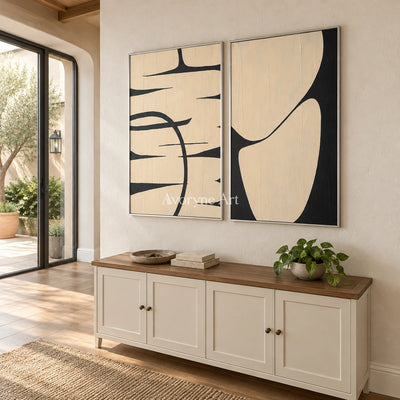 Muted Trace black ivory line art diptych with a silver frame in an entryway