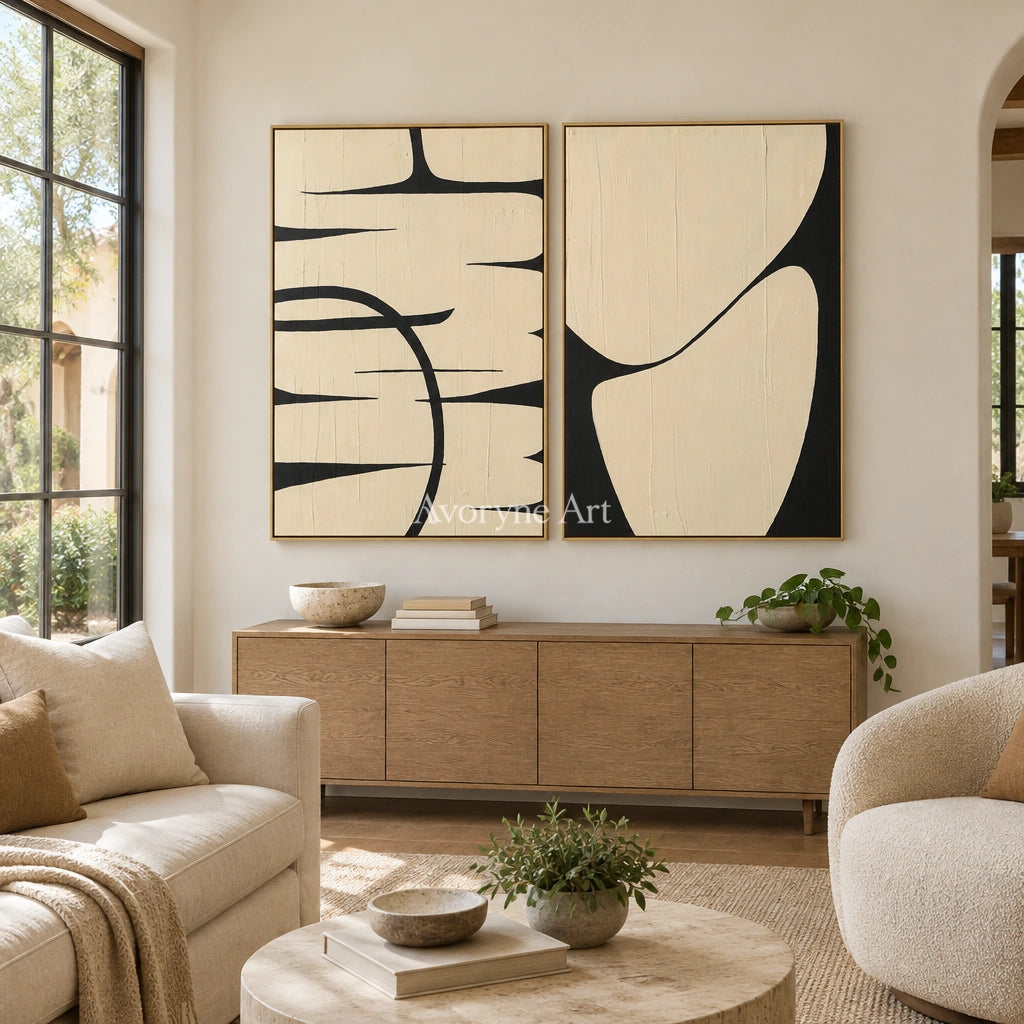 Muted Trace black ivory line art diptych with a gold frame hanging in a living room
