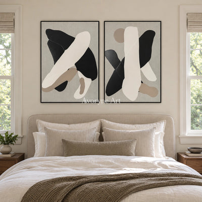 Muted Sonata black neutral organic art diptych with a black frame above a bed in a bedroom