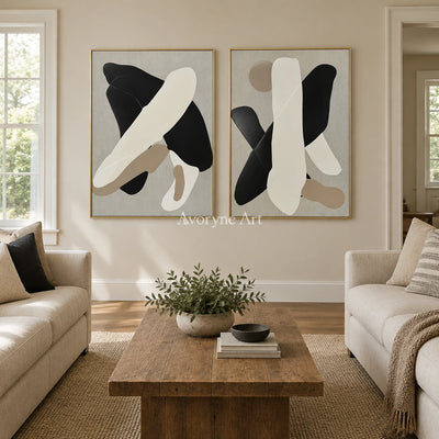 Muted Sonata black neutral organic art diptych with a gold frame hanging in a living room