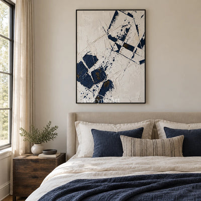 Earthen Reverie blue ivory grid wall art with a black frame above a bed in a bedroom
