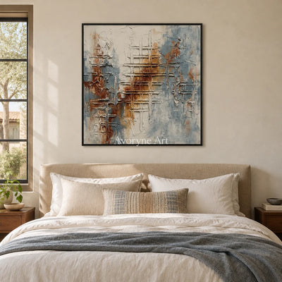 Woven Verse blue rust texture wall art with a black frame above a bed in a bedroom