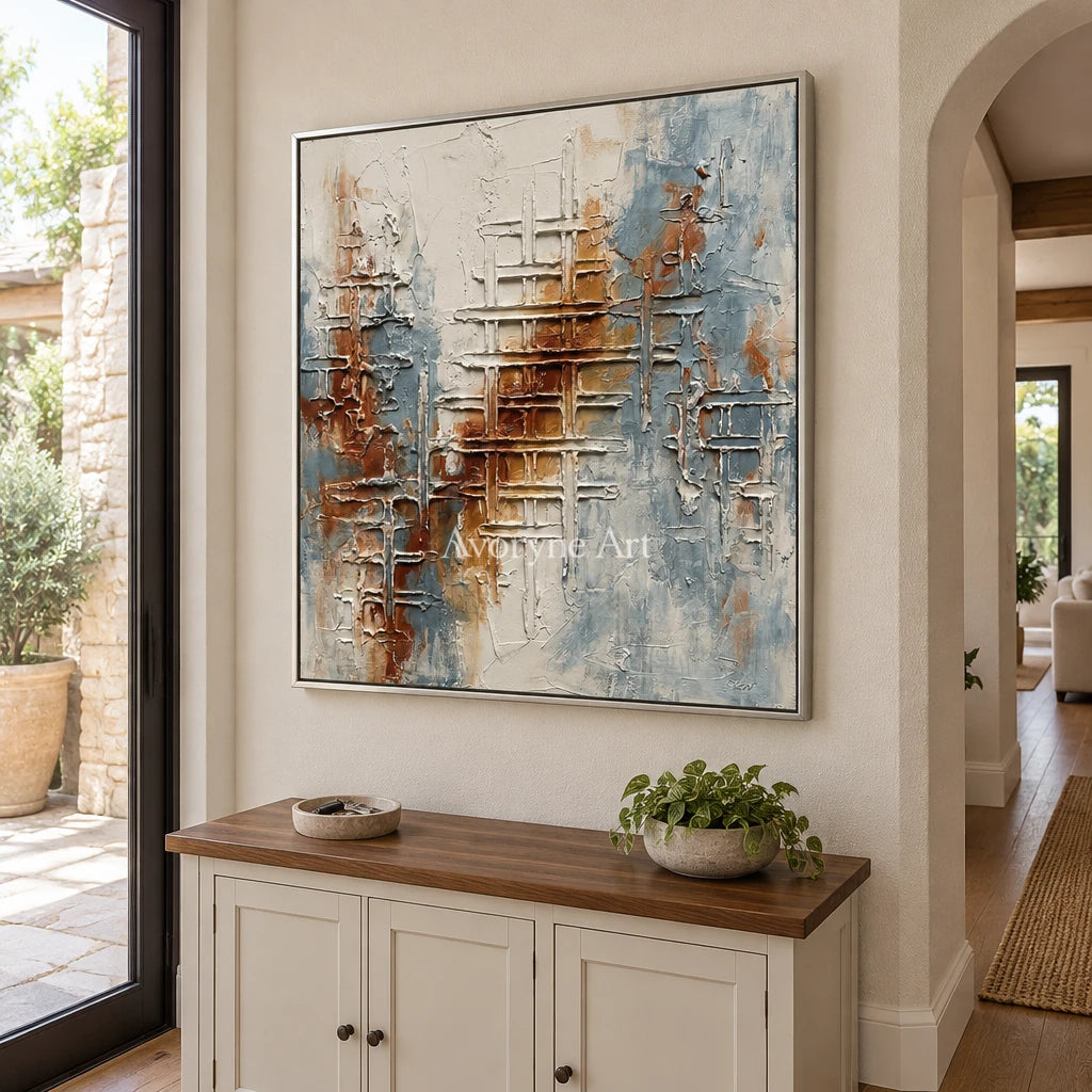 Woven Verse blue rust texture wall art with a silver frame in an entryway