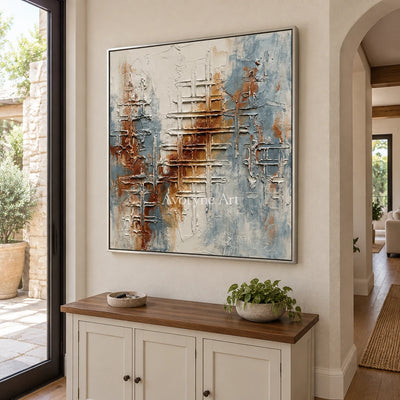 Woven Verse blue rust texture wall art with a silver frame in an entryway