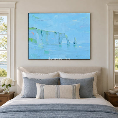 Tender Drift coastal landscape wall art with a black frame above a bed in a bedroom