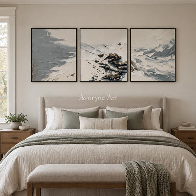 Restful Reverie coastal landscape triptych with a black frame above a bed in a bedroom