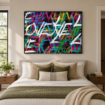 Hidden Verse colorful love wall art with a black frame above a bed in a bedroom