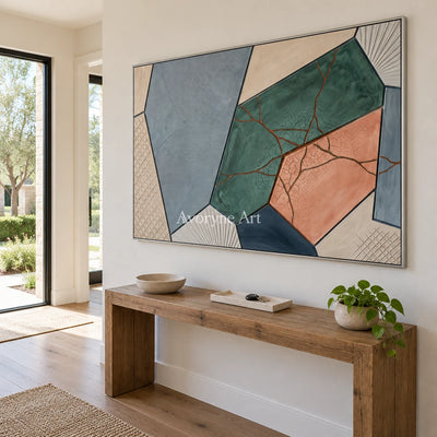 Still Refrain earth patch texture wall art with a silver frame in an entryway