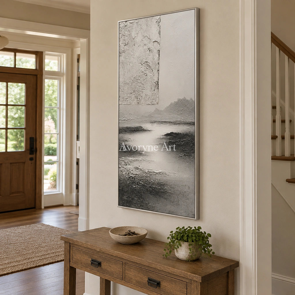 Pale Refrain gray water landscape wall art with a silver frame in an entryway