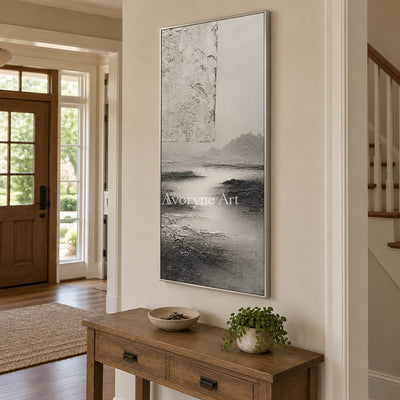 Pale Refrain gray water landscape wall art with a silver frame in an entryway