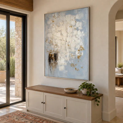 Gentle Haven ivory gold relief wall art with a silver frame in an entryway