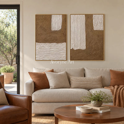 Muted Current neutral fold relief diptych with a gold frame hanging in a living room
