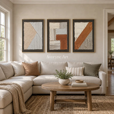 Soft Field neutral geometric relief triptych with a gold frame hanging in a living room