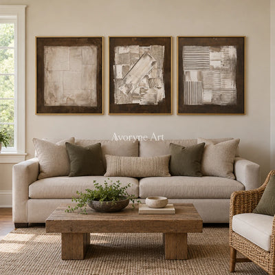 Hushed Field neutral geometric relief triptych with a gold frame hanging in a living room