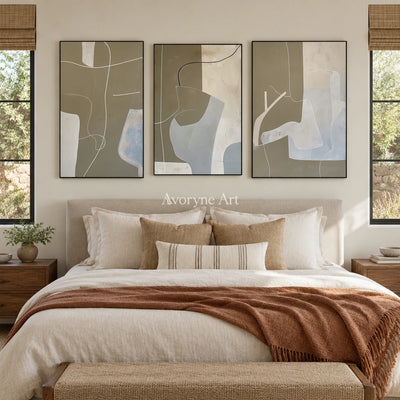 Muted Passage neutral organic art triptych with a black frame above a bed in a bedroom