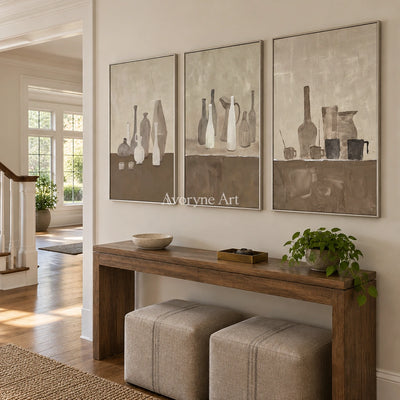 Muted Verse neutral pottery art triptych with a silver frame in an entryway