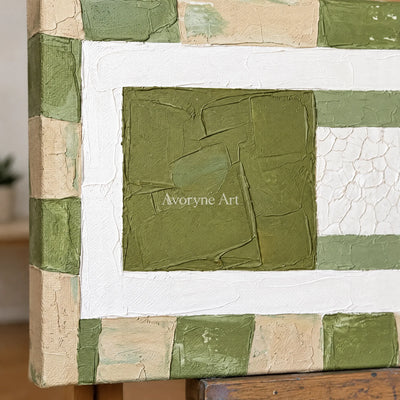 Close-up of the hand-painted texture of Soft Measure olive ivory grid wall art on an easel