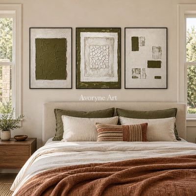 Earthen Field olive ivory grid triptych with a black frame above a bed in a bedroom