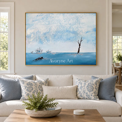 Blue Current snow branch wall art with a gold frame hanging in a living room