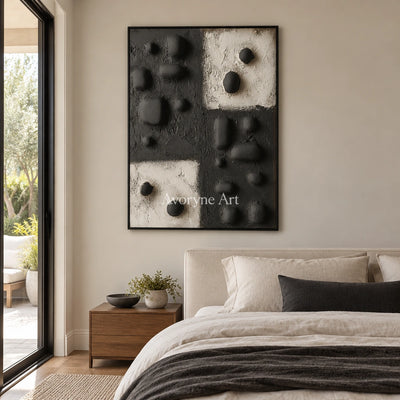 Muted Refrain stone dot relief wall art with a black frame above a bed in a bedroom