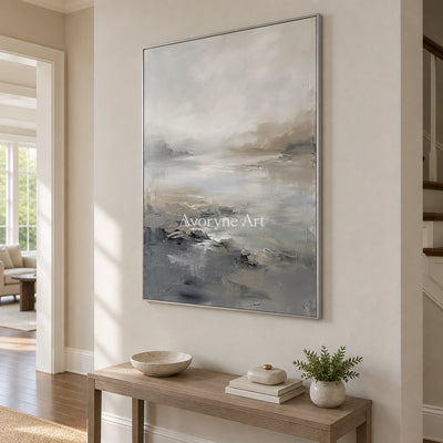 Winding Solace waterside landscape wall art with a silver frame in an entryway